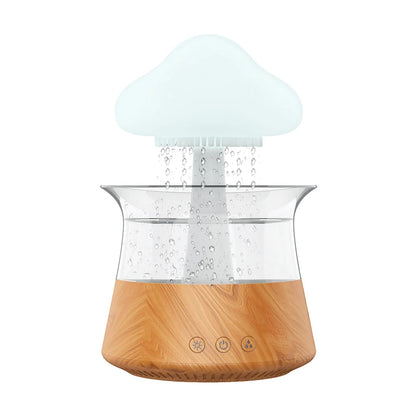 Rain cloud humidifier with a wood grain base, featuring cascading water droplets and a soft glowing light for a calming ambiance.